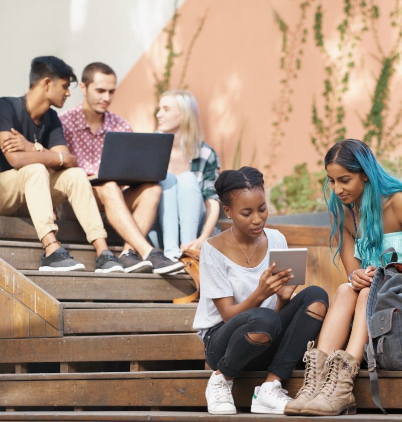 The students stairs. Shot of a group of young students enjoying a break outdoors on campus.